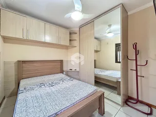 Quarto com cama de madeira e armário de parede.