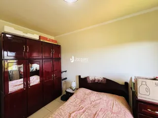 Quarto com armários de madeira e cama no interior de uma residência.