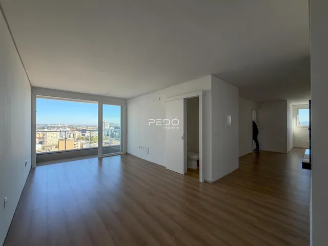 Sala de estar com piso de madeira e vista para a cidade.