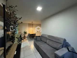 Sala de estar com sofá e piso de cerâmica em um imóvel em Lajeado.