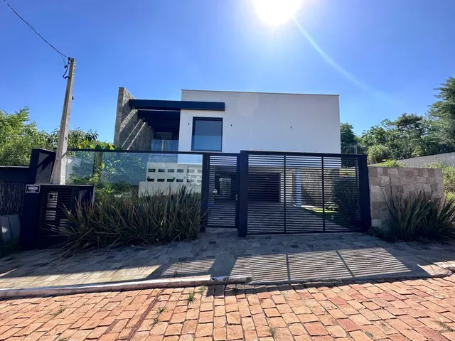 Fachada de uma residência em Lajeado, Brasil, com cerca e paisagismo na frente.