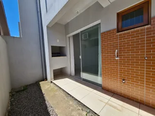 Fachada de um imóvel com parede de tijolos vermelhos e porta de vidro.