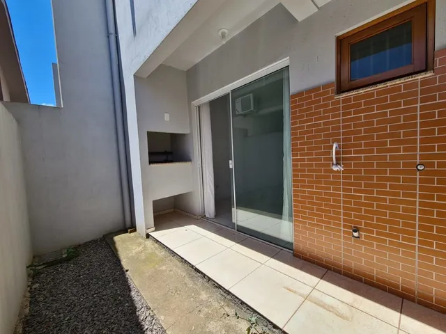 Fachada de um imóvel com parede de tijolos vermelhos e porta de vidro.