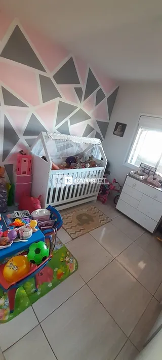 Quarto infantil com berço branco e decoração colorida.