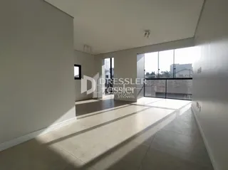 Interior de um ambiente com piso claro e paredes brancas iluminado pela luz natural.