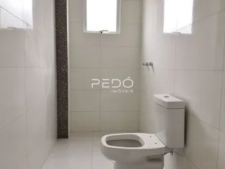 Foto do interior de um banheiro com revestimento branco.