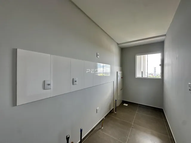 Hall de entrada com paredes brancas e piso cinza claro.