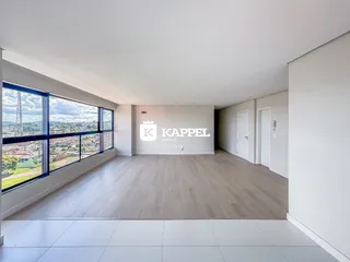 Uma sala ampla com grande janela que oferece uma vista panorâmica da paisagem.