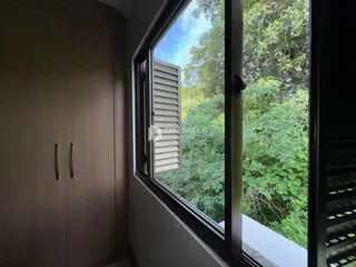 Vista da janela de uma propriedade em Lajeado, Brasil com vegetação exuberante.