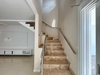 Vista de uma escadaria com degraus de mármore em um interior residencial.