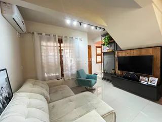 Sala de estar com sofá e janela em um imóvel no Brasil.