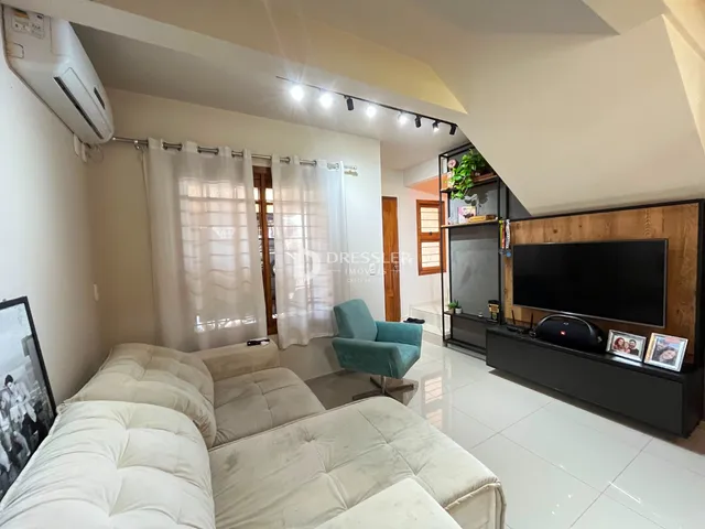 Sala de estar com sofá e janela em um imóvel no Brasil.