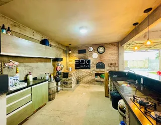 Interior de uma cozinha com paredes de tijolo aparente e armários de madeira.