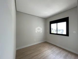 Ambiente interno de um cômodo com piso de madeira clara e janela grande.