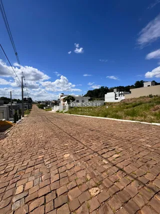 Vista da rua pavimentada com pedras no entorno de uma residência em Lajeado.