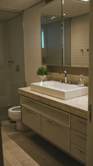 Foto de um banheiro com bancada de mármore e azulejos brancos.