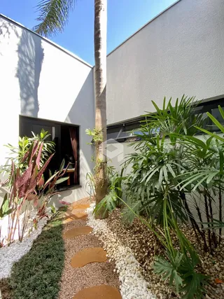 Jardim lateral com caminho de pedras e vegetação exuberante em Lajeado.