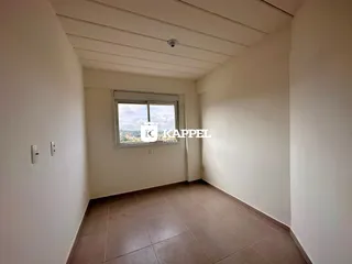 Foto interna de uma sala com piso de cerâmica e janela.