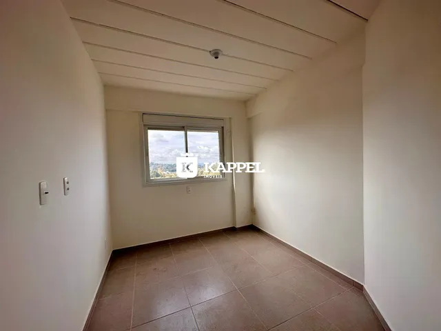 Foto interna de uma sala com piso de cerâmica e janela.