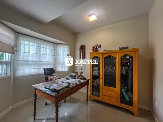 Escritório com mesa de madeira e um armário amarelo na sala.
