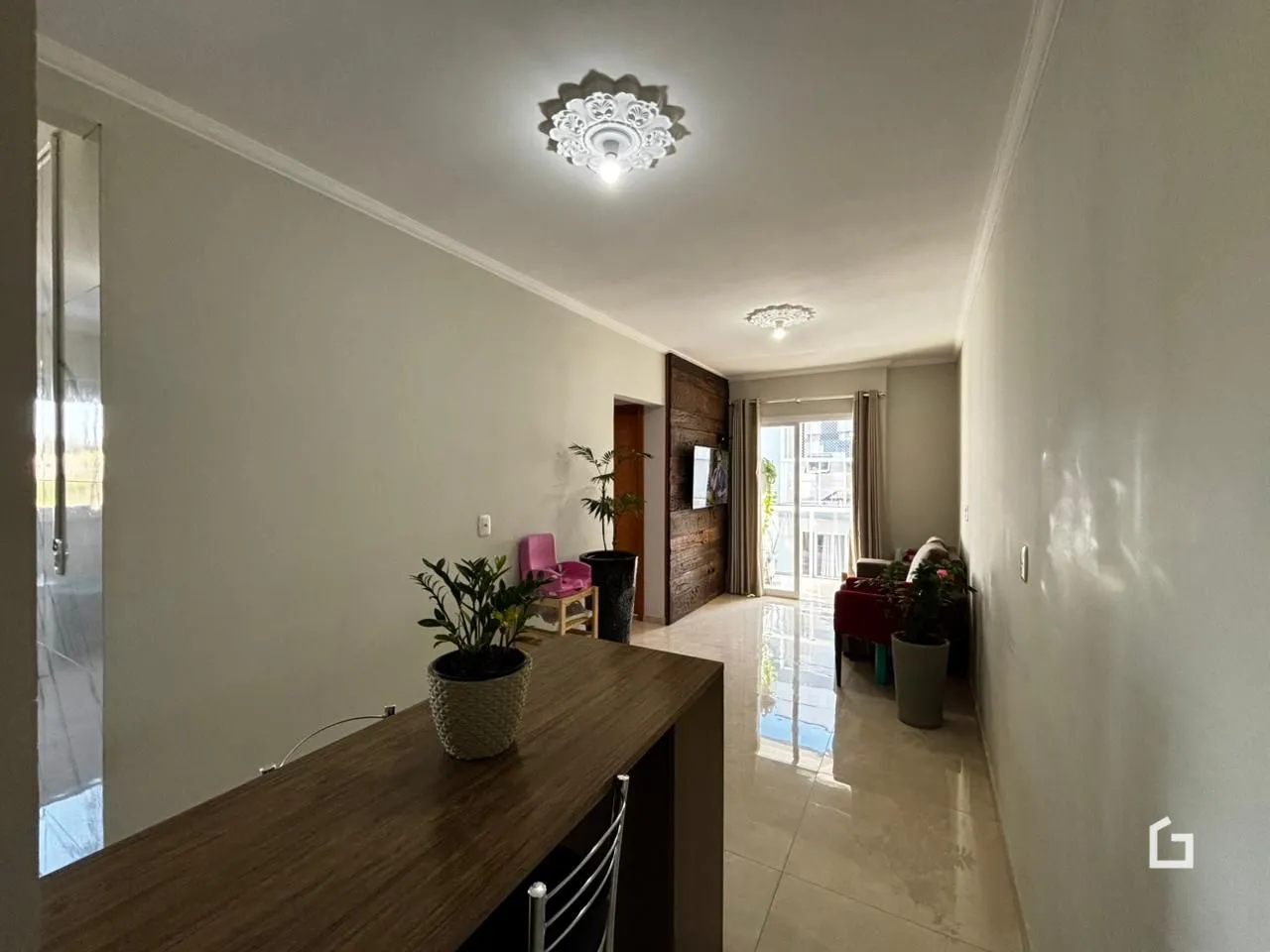 Hall de entrada interno de uma residência com paredes brancas.