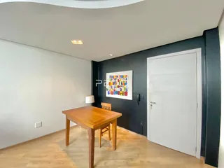 Vista interna de um ambiente com piso de madeira e parede escura.