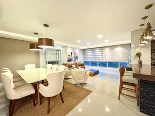Sala de estar com mesa de jantar e grandes janelas.