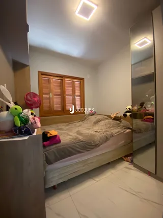 Quarto interno com cama e espelho.