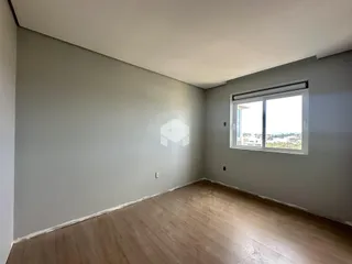 Uma sala com paredes cinzas e piso de madeira clara.