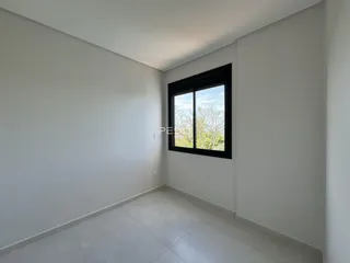 Ambiente interno de uma sala com paredes brancas e piso claro.