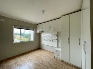 Cozinha com armários brancos e piso de cerâmica em um imóvel no Brasil.