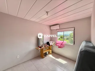 Quarto com cama e janela com vista para a paisagem.