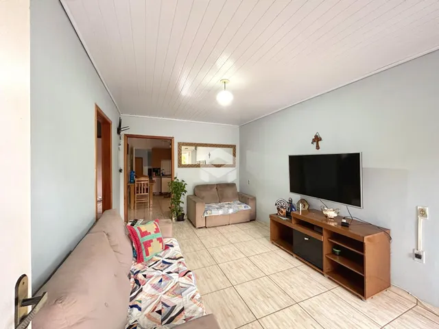 Sala de estar com sofá e televisão em um imóvel no Brasil.