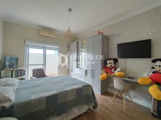Quarto com cama e televisão em um ambiente interno.