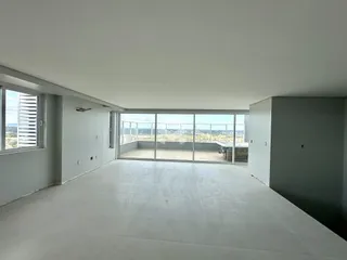 Ambiente interno de uma sala ampla com vista para a paisagem.