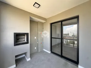 Hall de entrada com porta de vidro que se abre para uma vista externa.