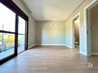 Sala de estar com piso de madeira e grande janela.