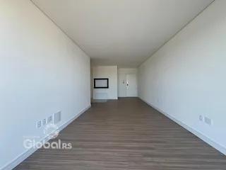 Hall de corredor com piso de madeira clara e paredes brancas.
