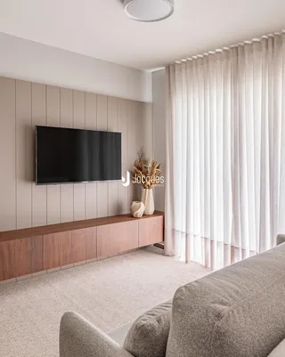 Sala de estar moderna com painel de parede e televisão.