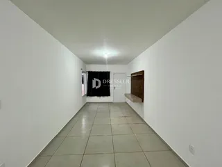 Corredor interno de uma residência com paredes brancas e piso de cerâmica.