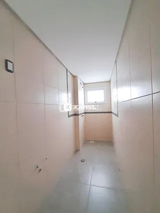 Corredor interno com paredes brancas e piso claro.