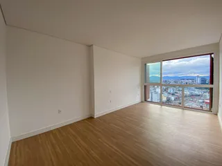 Sala de estar com piso de madeira e vista panorâmica da cidade.