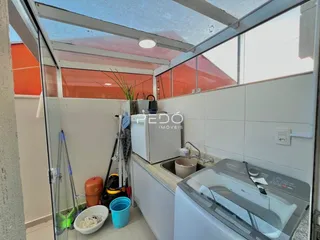 Foto de uma área de serviço com pia e máquina de lavar em um imóvel.