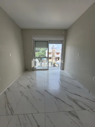 Hall de entrada com piso de mármore branco e porta de vidro.
