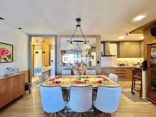A foto mostra uma sala de jantar com mesa de madeira e cadeiras modernas.