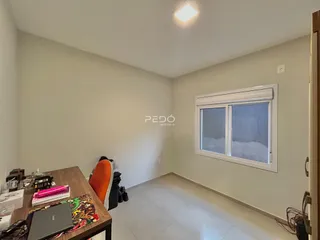 Interior de uma sala com paredes claras e piso de cerâmica.