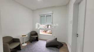 Sala de estar com paredes brancas e piso de madeira clara.