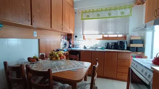 Uma sala de jantar com móveis de madeira e armários na cozinha.