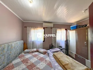 Quarto com cama e armário de madeira em um ambiente interno.
