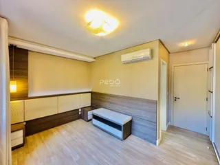 Sala de estar com piso de madeira clara e móveis planejados.